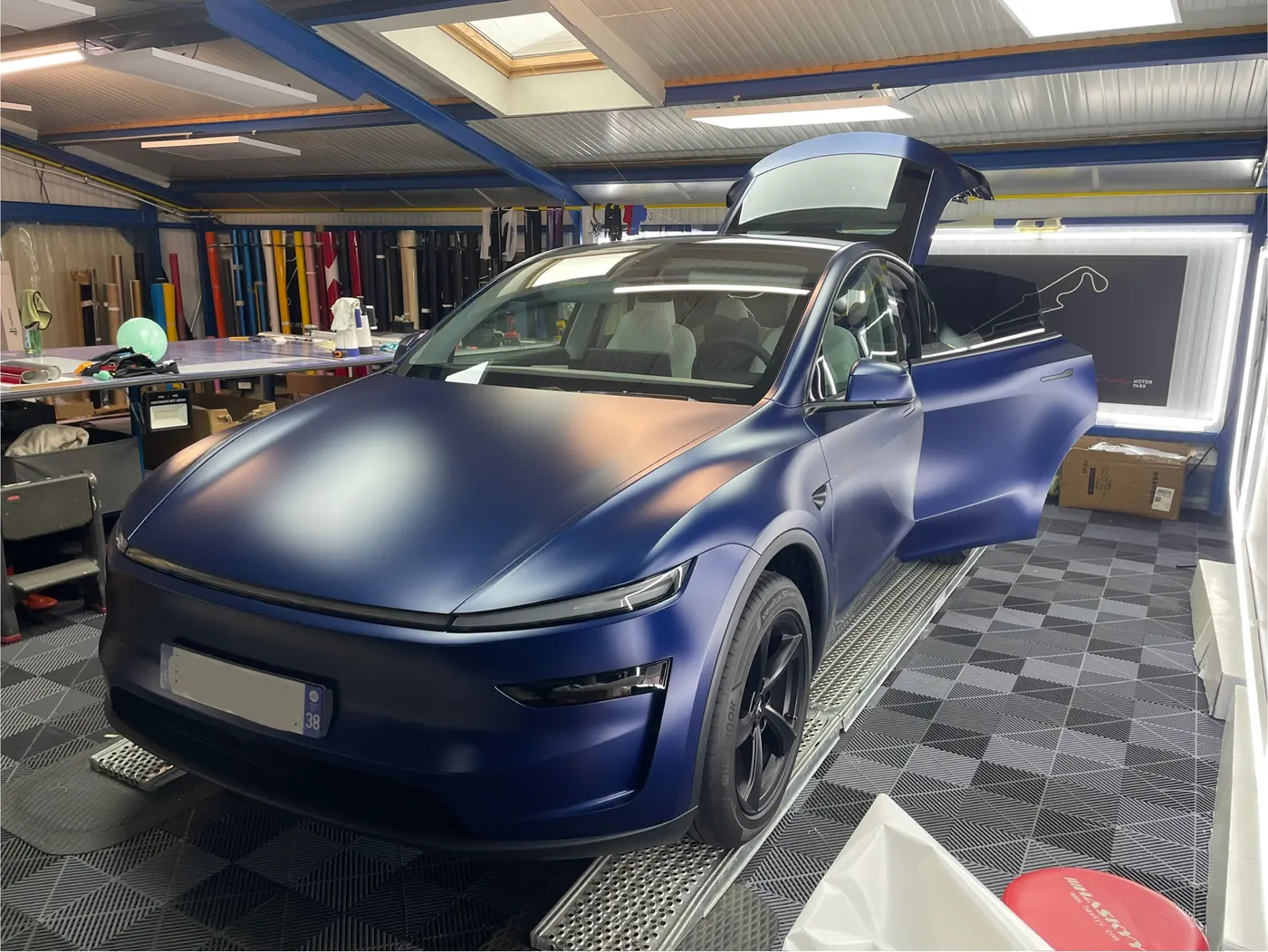 Voiture électrique en cours de protection avec un film PPF transparent